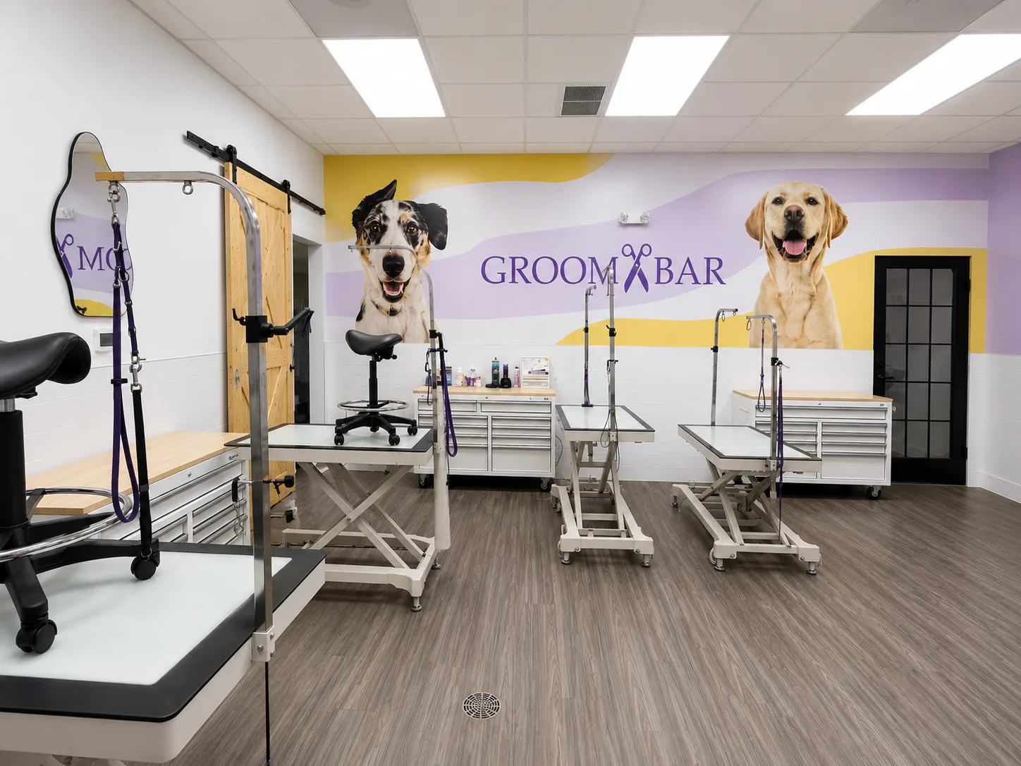 Open Groombar grooming floor with hydraulic tables and branded mural